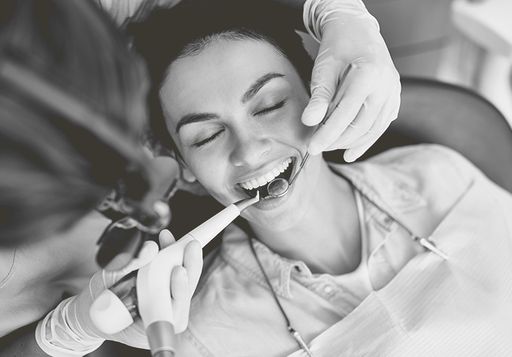Smiling patient getting a work done by dentist.