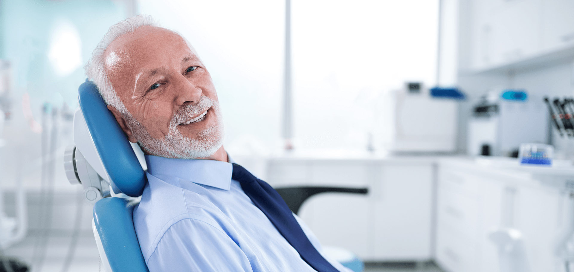 A patient proudly showing off his new dental crown